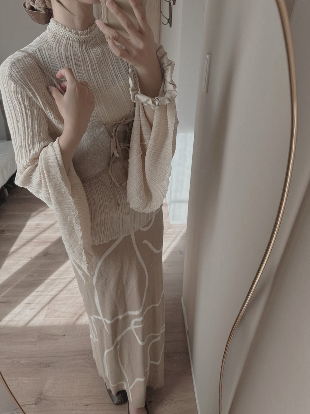 ホワイト系のニット/セーター、ベージュ系のその他トップス、ホワイト系のネックレスを着用したレディースの冬コーディネートの3枚目の写真