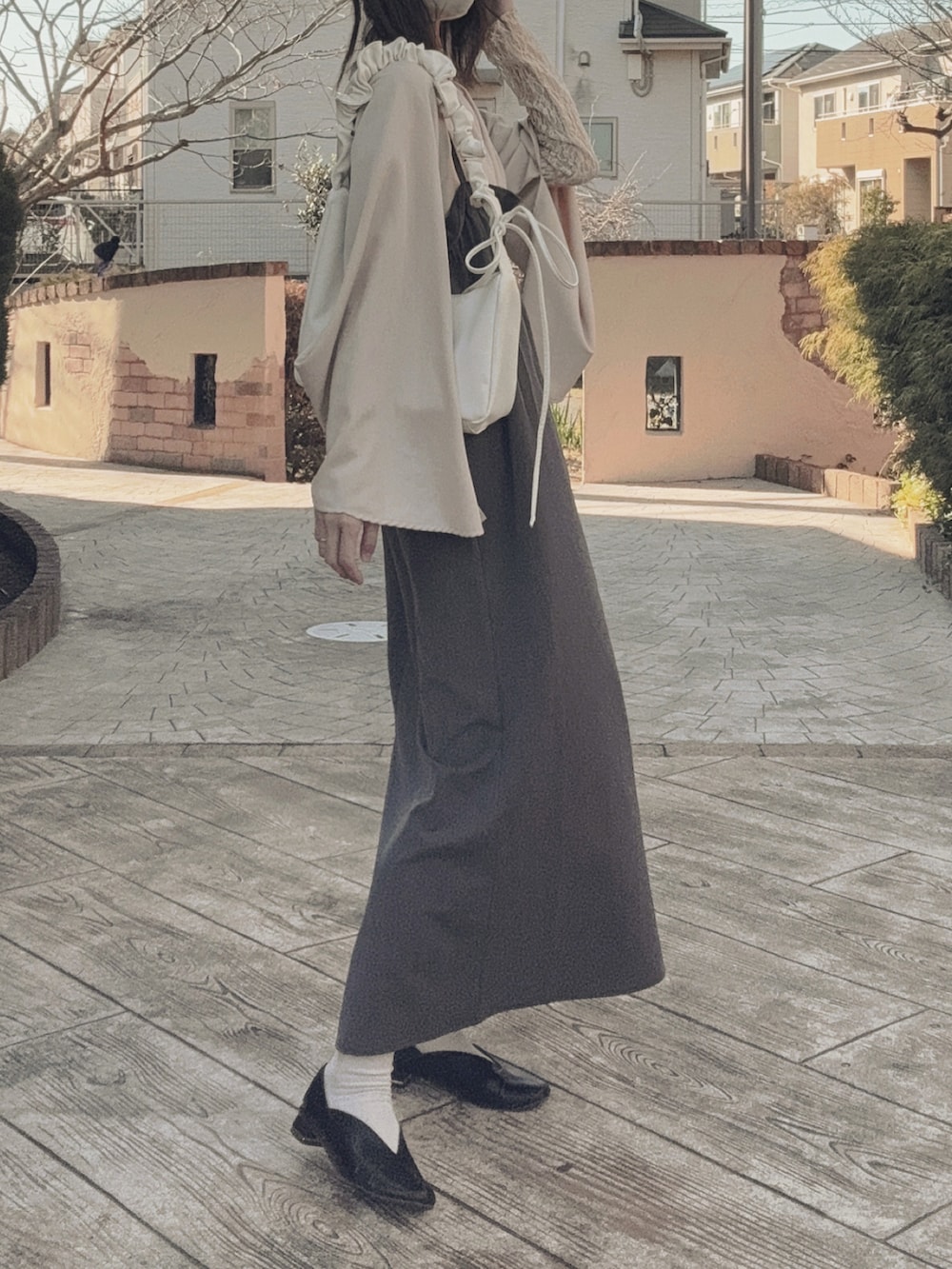 ベージュ系のテーラードジャケット、ホワイト系のショルダーバッグ、グレー系のワンピース/ドレスを着用したレディースの冬コーディネートの3枚目の写真