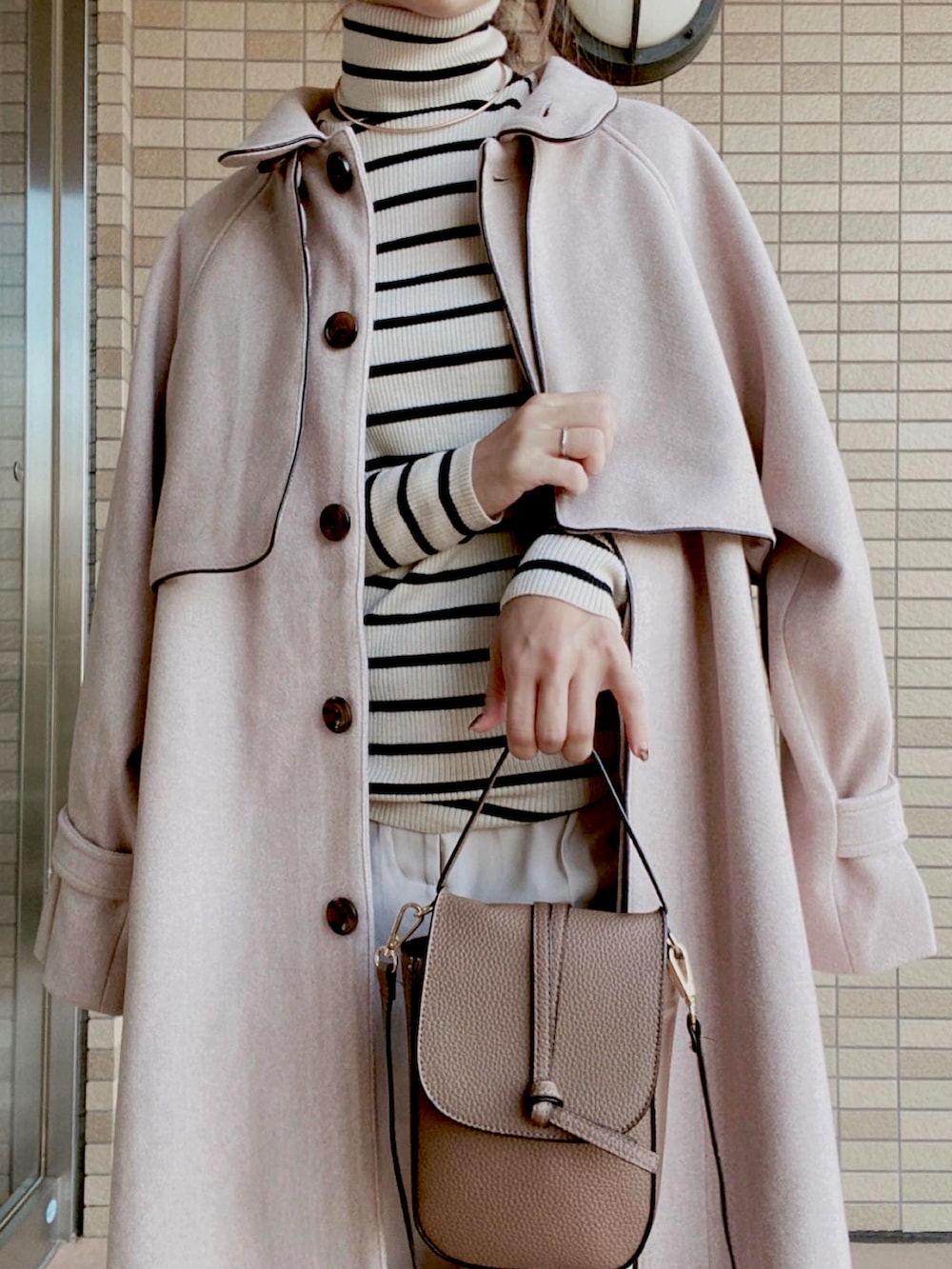 ベージュ系のジャケット/アウター、ホワイト系のニット/セーター、ホワイト系のパンツを着用したレディースの秋コーディネートの3枚目の写真