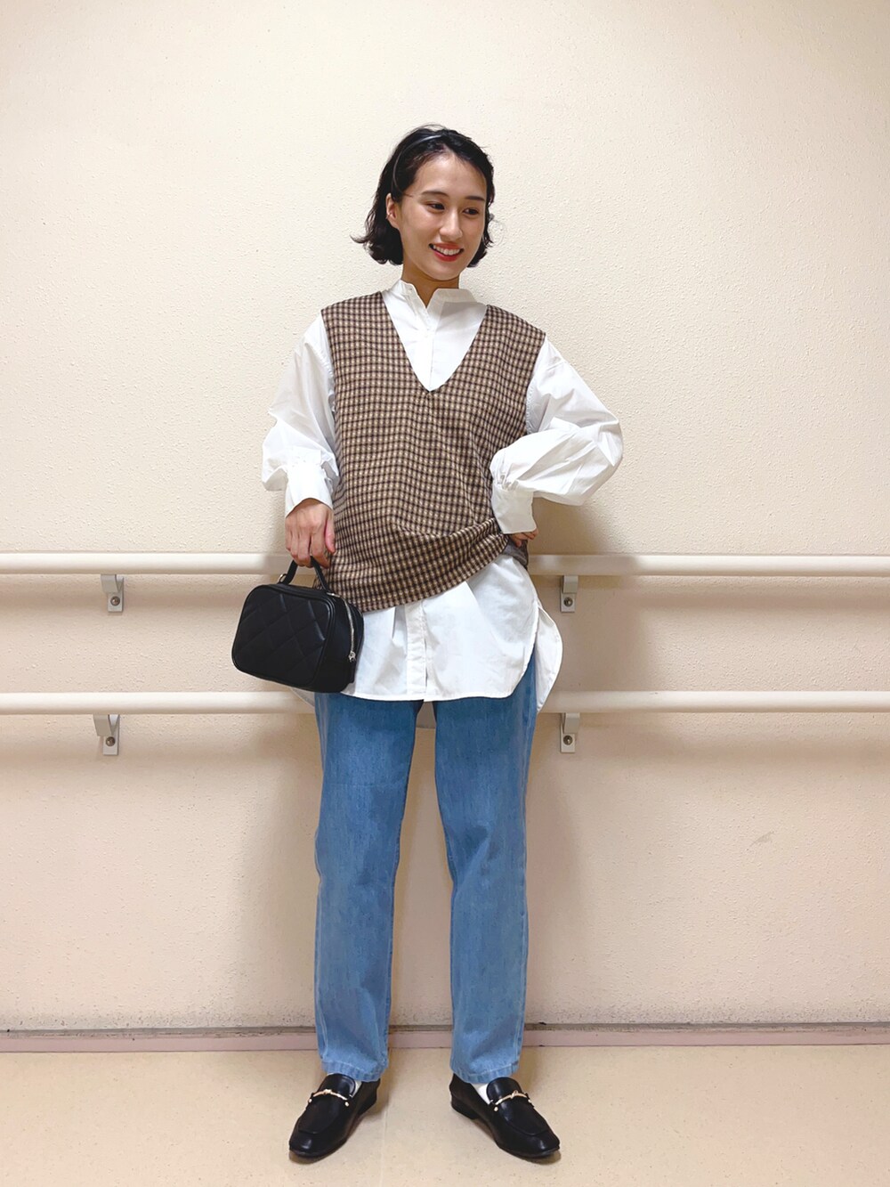 ブラウン系のニット/セーター、ホワイト系のシャツ/ブラウス、ブルー系のデニムパンツを着用したレディースの夏コーディネートの2枚目の写真