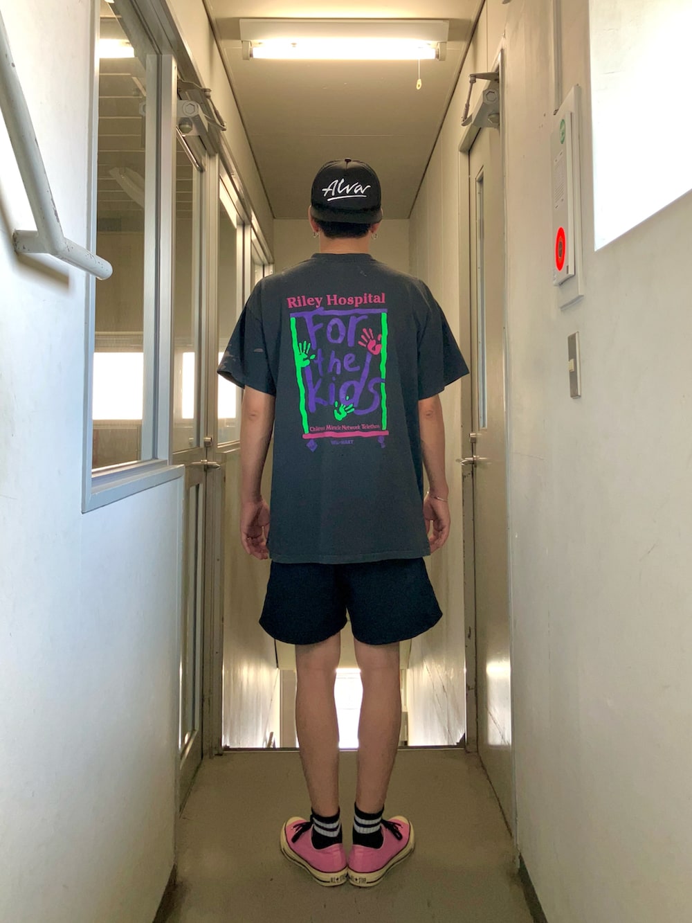 ブラック系のTシャツ/カットソー、ブラック系のパンツ、ピンク系のスニーカーを着用したメンズの夏コーディネートの2枚目の写真