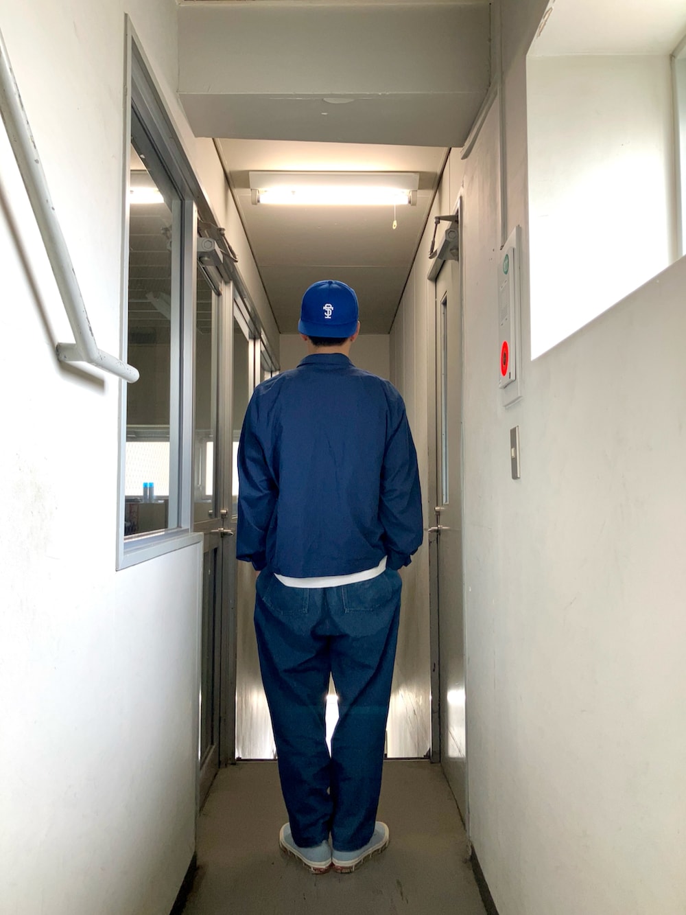 ブルー系のブルゾン、ブルー系のその他パンツ、ブルー系のスニーカーを着用したメンズの春コーディネートの2枚目の写真