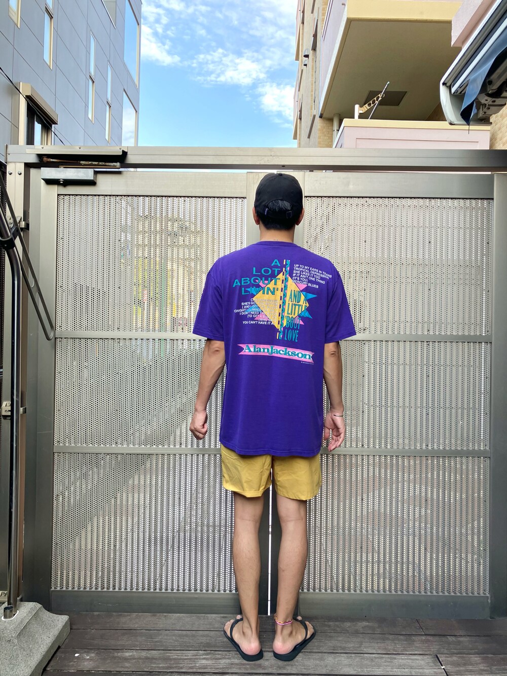 パープル系のTシャツ/カットソー、イエロー系のその他パンツ、ブラック系のビーチサンダルを着用したメンズの夏コーディネートの2枚目の写真