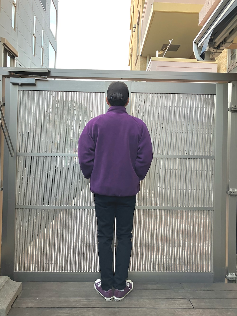 ブラック系のスウェット、パープル系のその他アウター、ブラック系のチノパンツを着用したメンズの冬コーディネートの2枚目の写真