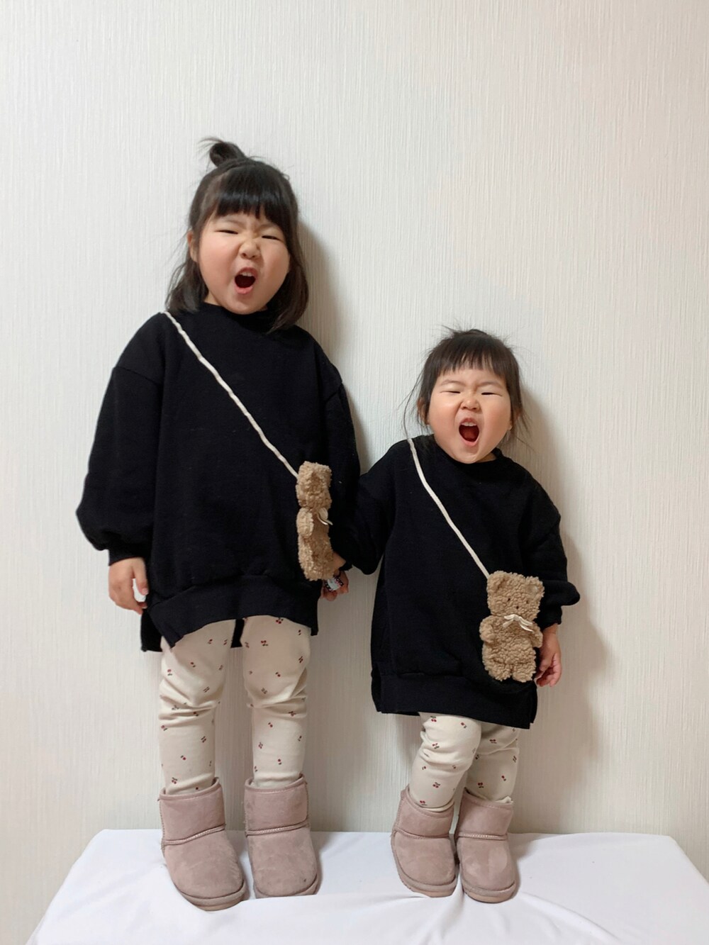 ブラック系のスウェット、ブラック系のスウェット、ピンク系のブーツを着用したキッズの冬コーディネートの2枚目の写真