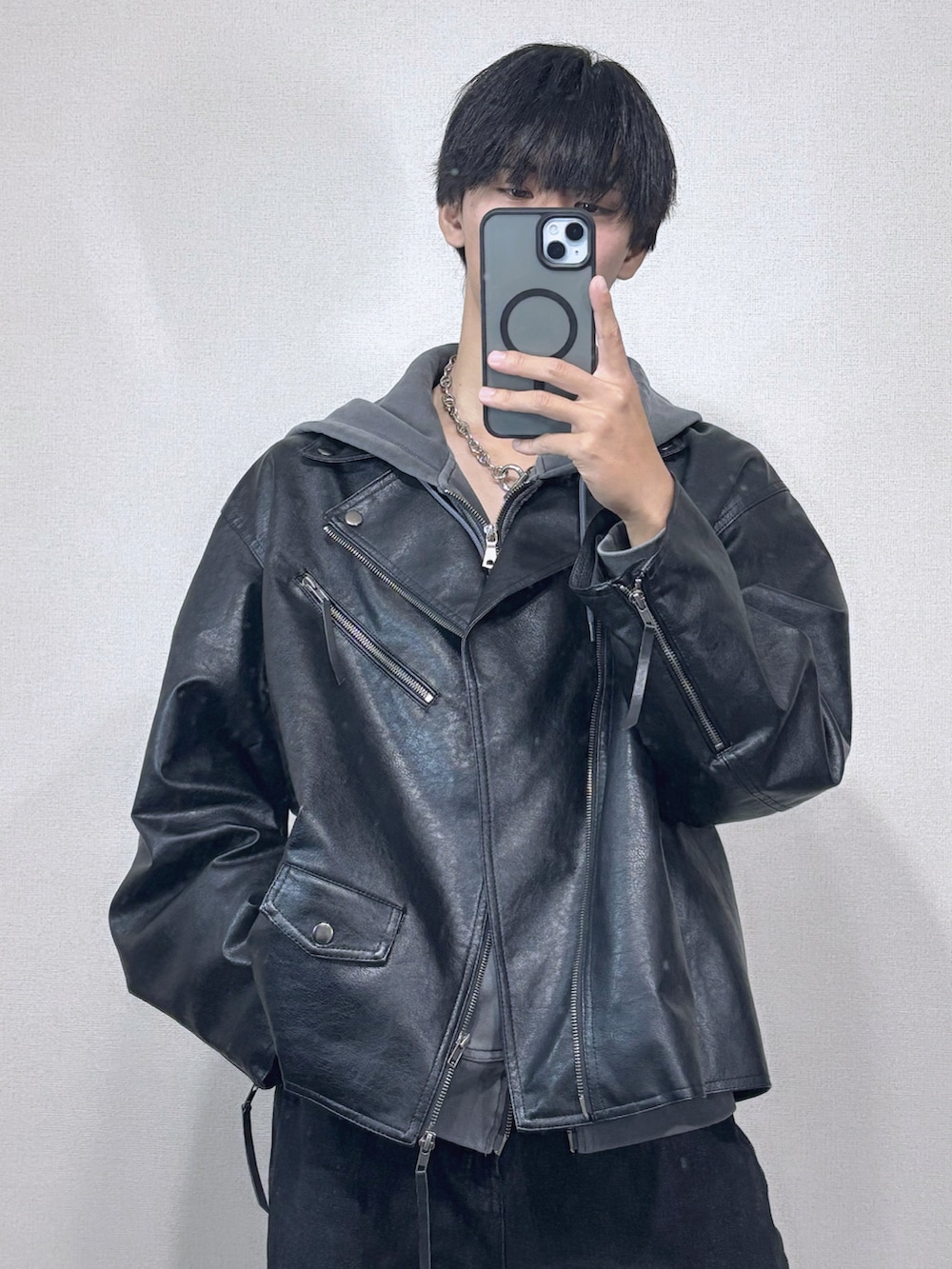 ブラック系のライダースジャケット、グレー系のパーカー、ブラック系のデニムパンツを着用したメンズの冬コーディネートの3枚目の写真