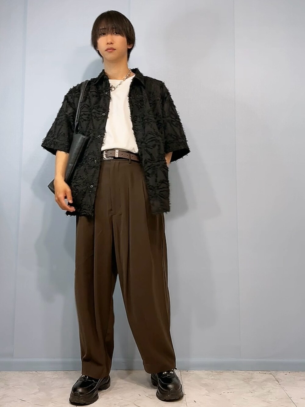 ブラック系のスニーカー、ブラウン系のパンツ、ブラック系のシャツ/ブラウスを着用したメンズの春コーディネートの2枚目の写真