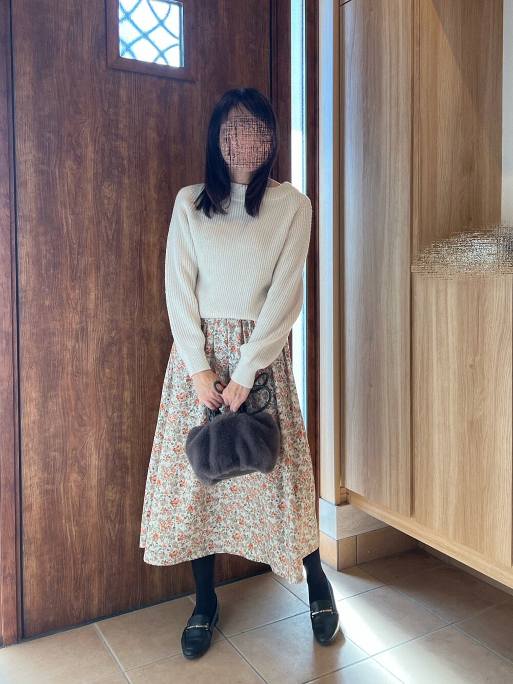 ホワイト系のスカート、ブラック系のローファー、ホワイト系のニット/セーターを着用したレディースの秋コーディネートの3枚目の写真