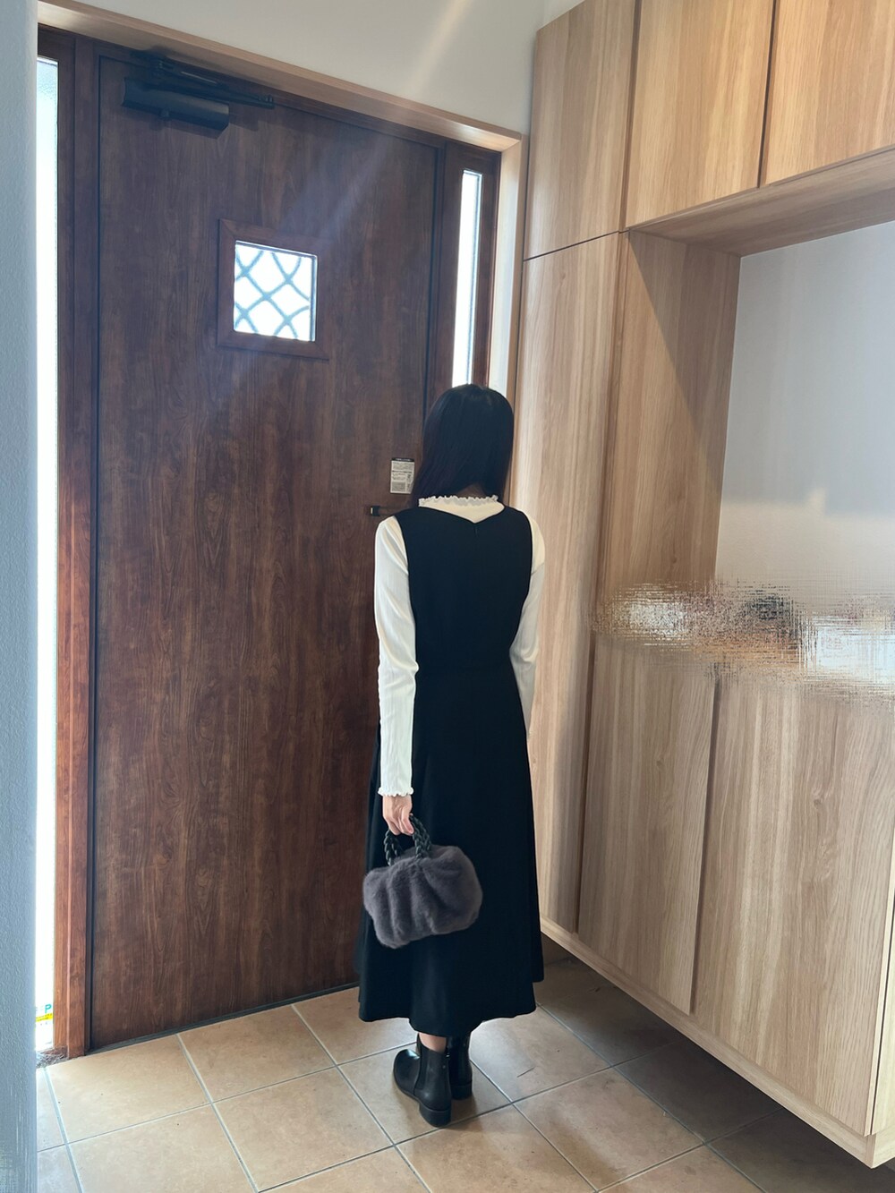 ブラック系のジャンパースカート、ホワイト系のTシャツ/カットソー、グレー系のハンドバッグを着用したレディースの秋コーディネートの3枚目の写真