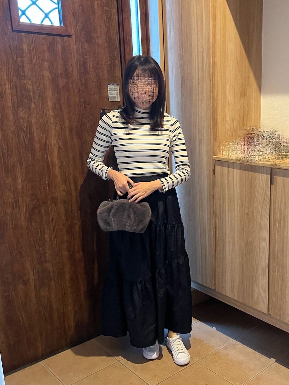 イエロー系のTシャツ/カットソー、ブラック系のスカート、グレー系のハンドバッグを着用したレディースの秋コーディネートの4枚目の写真