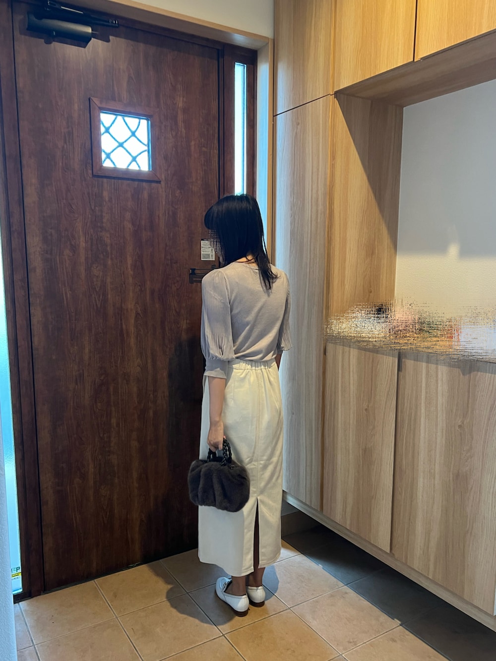 ホワイト系のスカート、ホワイト系のスリッポン、グレー系のTシャツ/カットソーを着用したレディースの秋コーディネートの4枚目の写真