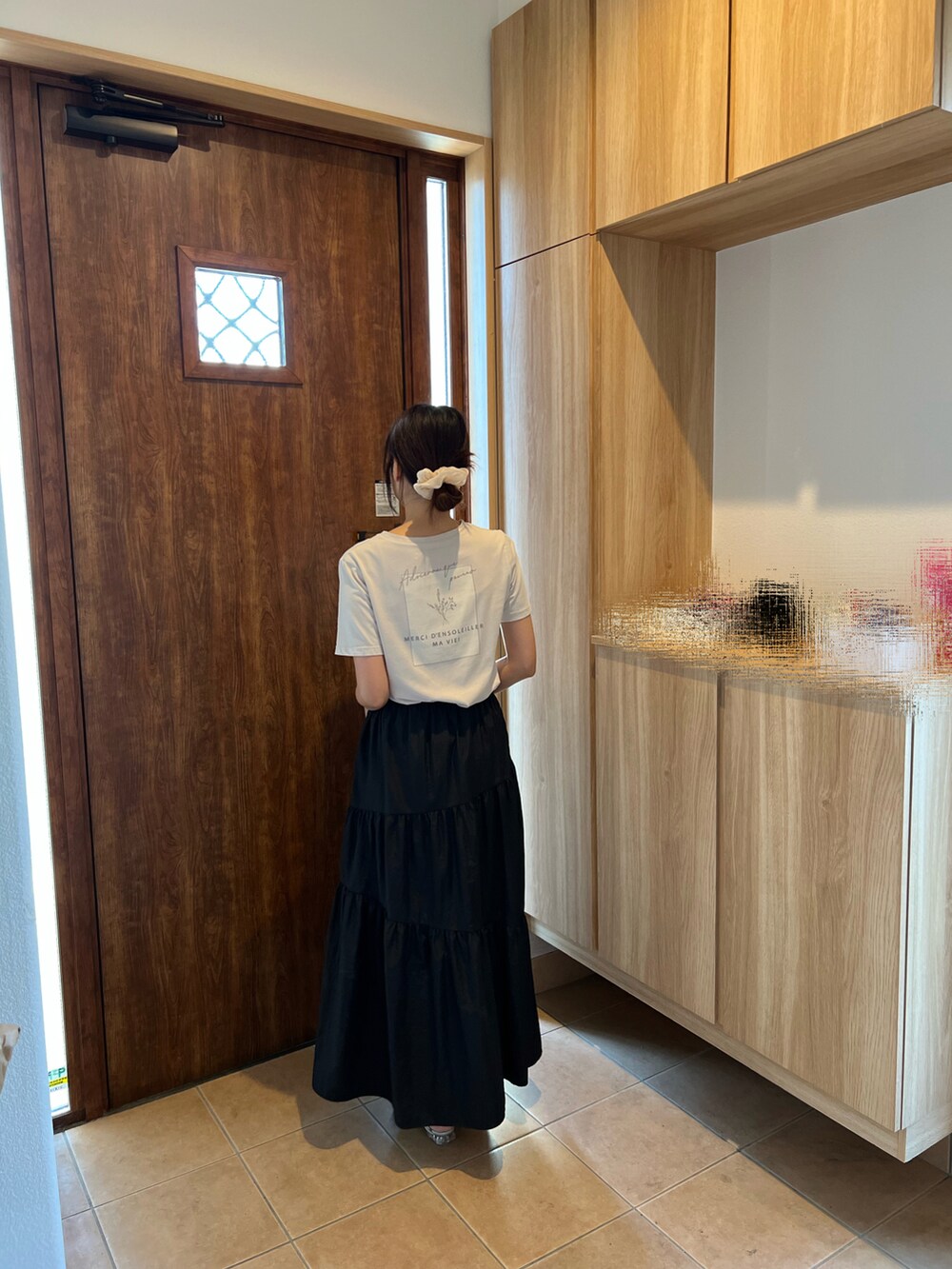 ベージュ系のTシャツ/カットソー、ブラック系のスカート、グレー系のサンダルを着用したレディースの夏コーディネートの2枚目の写真