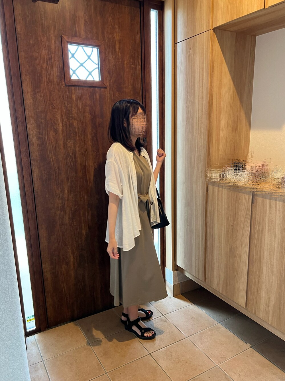 グリーン系のワンピース、ブラック系のサンダル、ブラック系のハンドバッグを着用したレディースの夏コーディネートの2枚目の写真