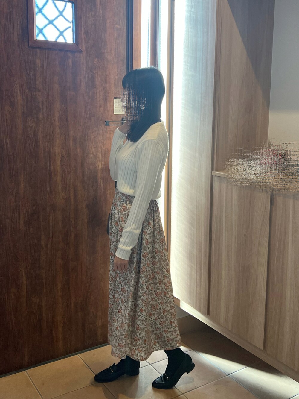 ホワイト系のニット/セーター、ホワイト系のスカート、グレー系のハンドバッグを着用したレディースの冬コーディネートの3枚目の写真