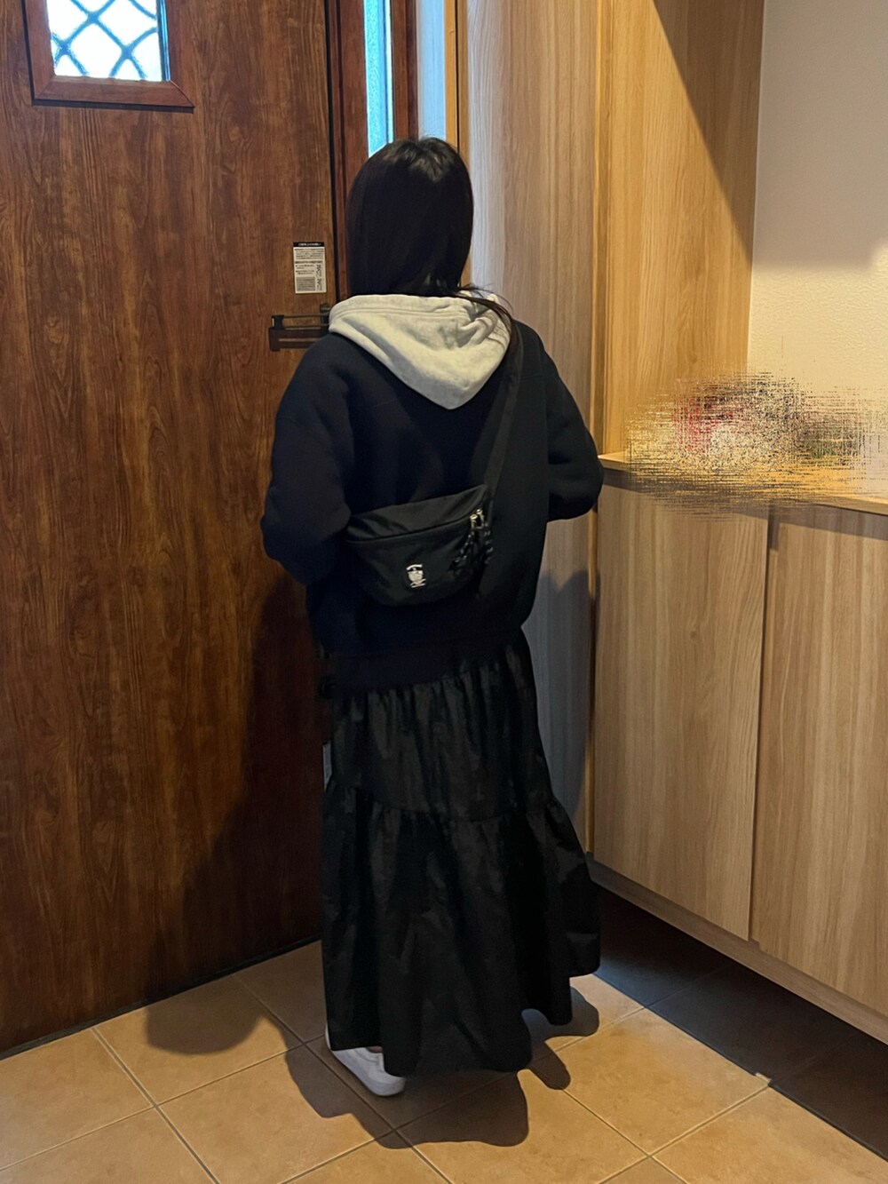 イエロー系のTシャツ/カットソー、ブラック系のスカート、グレー系のハンドバッグを着用したレディースの秋コーディネートの5枚目の写真