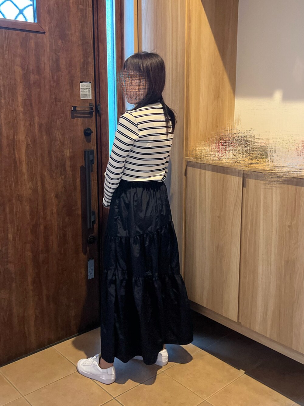 イエロー系のTシャツ/カットソー、ブラック系のスカート、グレー系のハンドバッグを着用したレディースの秋コーディネートの3枚目の写真