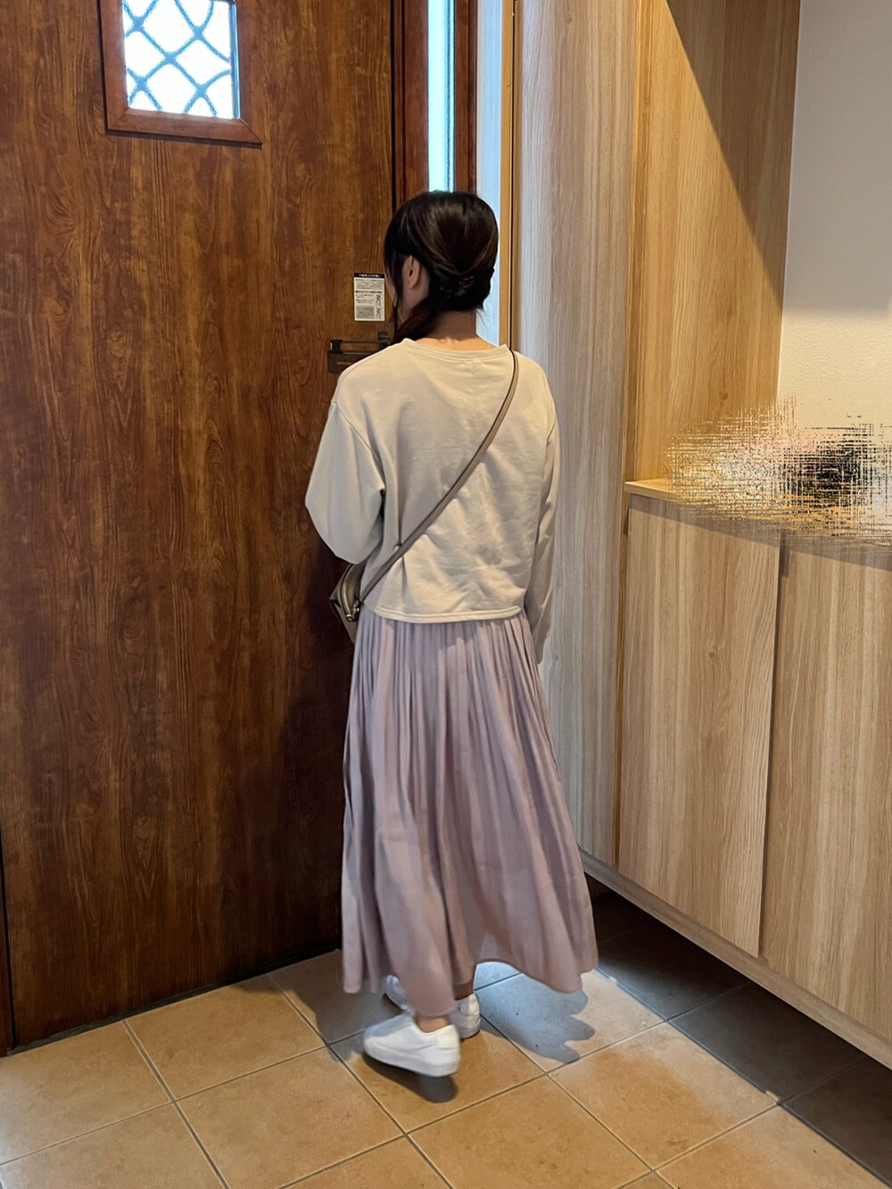 ベージュ系のスウェット、ベージュ系のショルダーバッグ、ピンク系のスカートを着用したレディースの春コーディネートの3枚目の写真