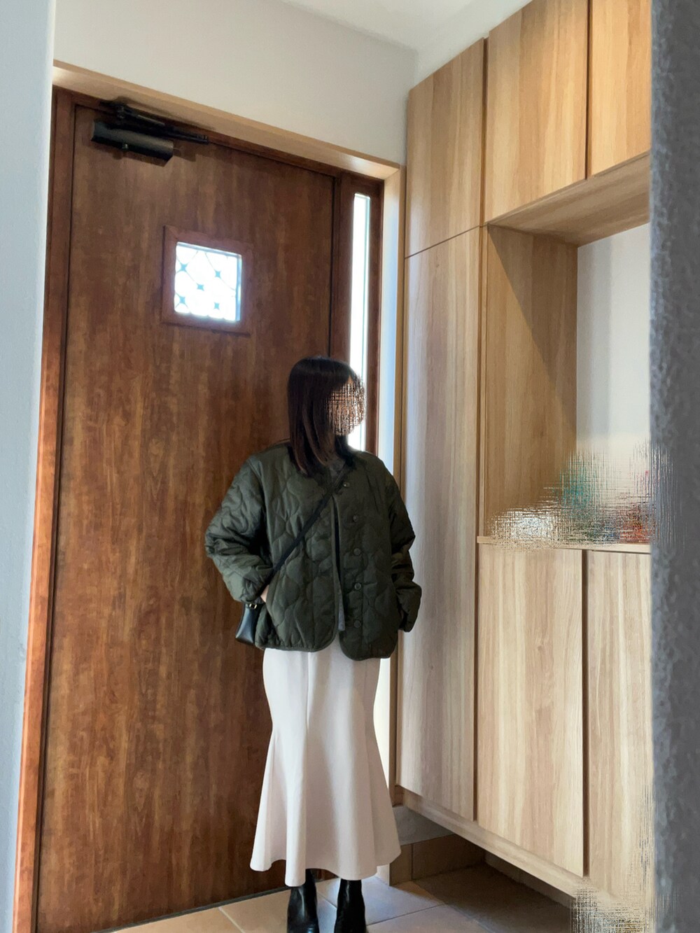 グレー系のニット/セーター、ホワイト系のスカート、ブラック系のブーツを着用したレディースの冬コーディネートの2枚目の写真