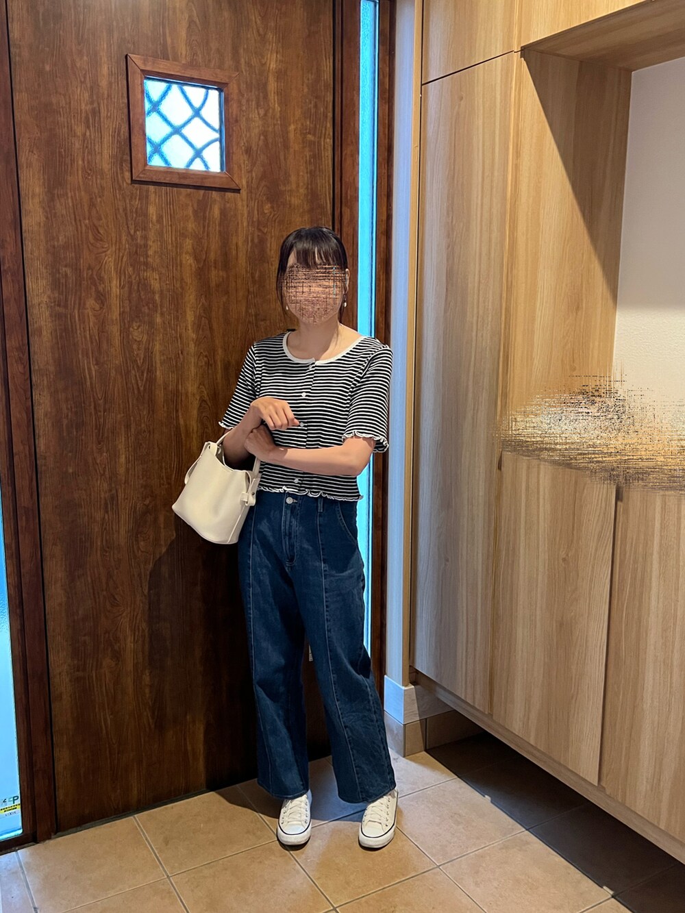 ブラック系のTシャツ/カットソー、ブルー系のデニムパンツ、ホワイト系のスニーカーを着用したレディースの春コーディネートの2枚目の写真