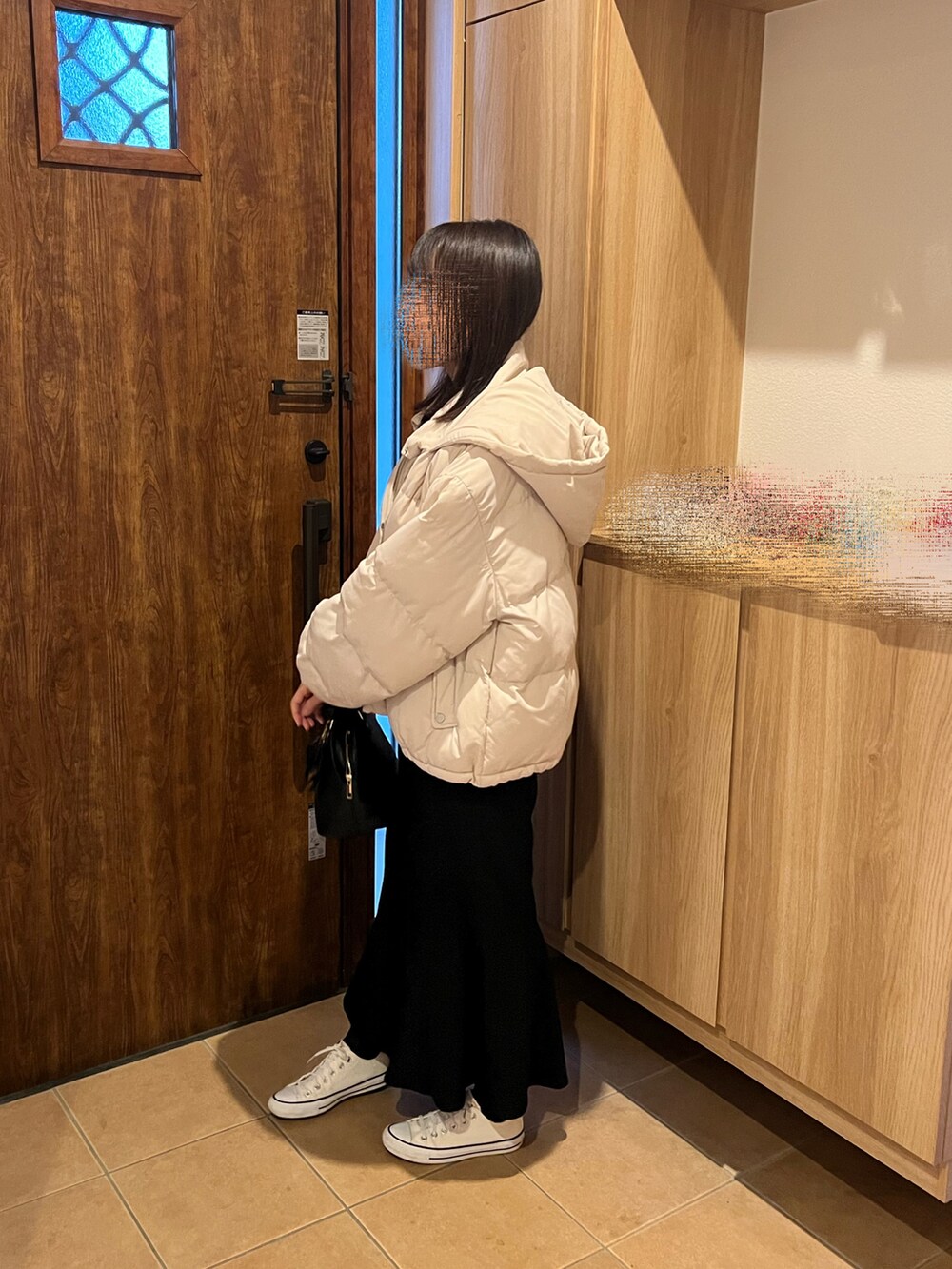 ブラック系のスカート、グレー系のスウェット、ホワイト系のダウンジャケット/コートを着用したレディースの冬コーディネートの2枚目の写真