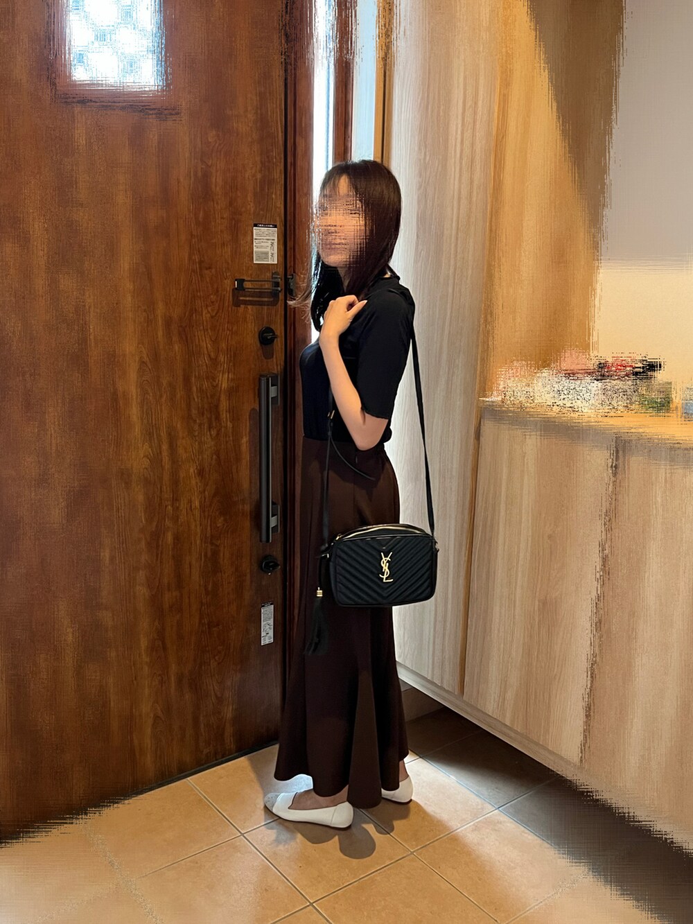 ブラック系のショルダーバッグ、ブラウン系のスカート、ホワイト系のパンプスを着用したレディースの秋コーディネートの2枚目の写真
