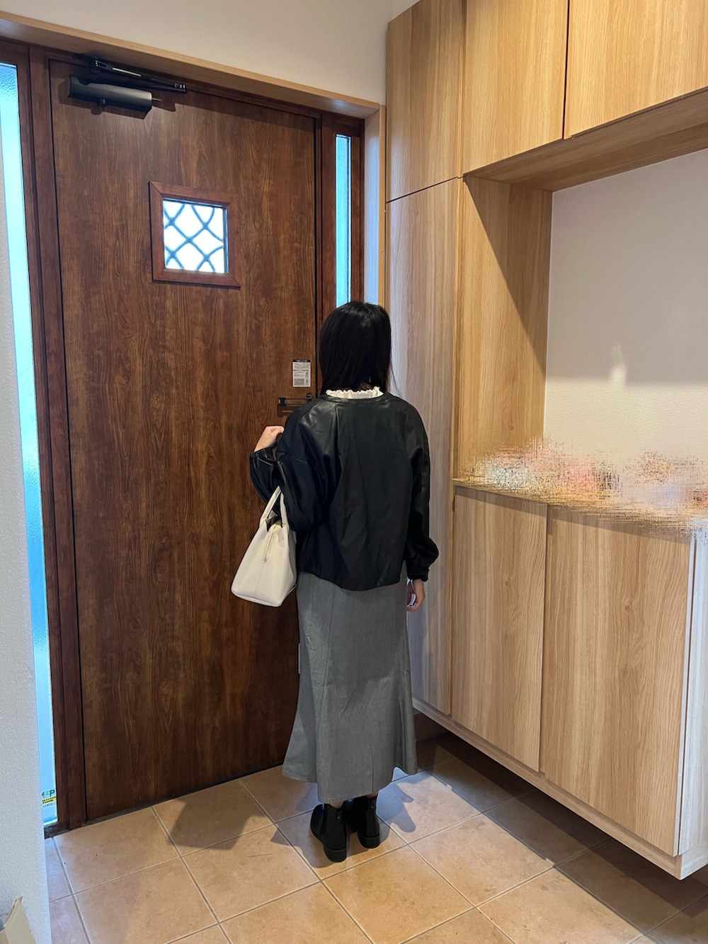 グレー系のジャンパースカート、ブラック系のブルゾン、ホワイト系のTシャツ/カットソーを着用したレディースの秋コーディネートの2枚目の写真