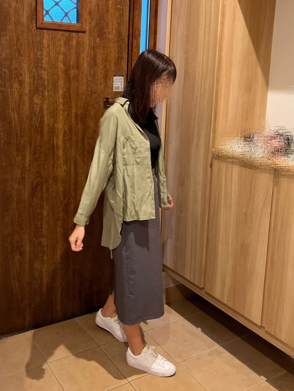 グリーン系のシャツ/ブラウス、ブラック系のTシャツ/カットソー、グレー系のスカートを着用したレディースの秋コーディネートの2枚目の写真