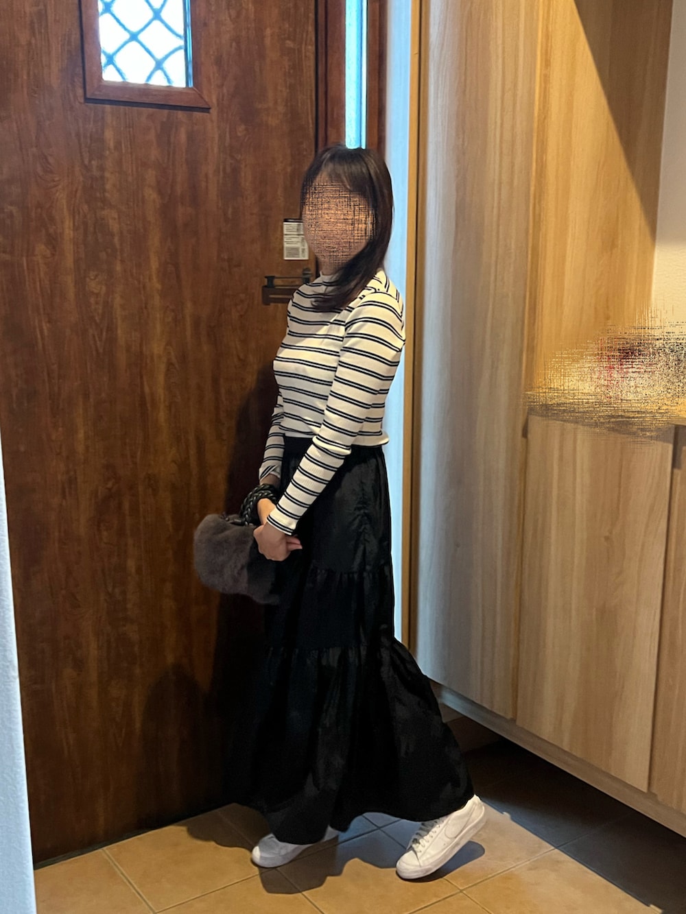 イエロー系のTシャツ/カットソー、ブラック系のスカート、グレー系のハンドバッグを着用したレディースの秋コーディネートの2枚目の写真