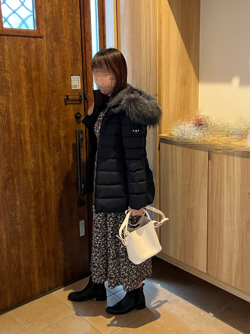 ブラック系のワンピース、ブラック系のダウンジャケット/コート、ブラック系のブーツを着用したレディースの秋コーディネートの5枚目の写真