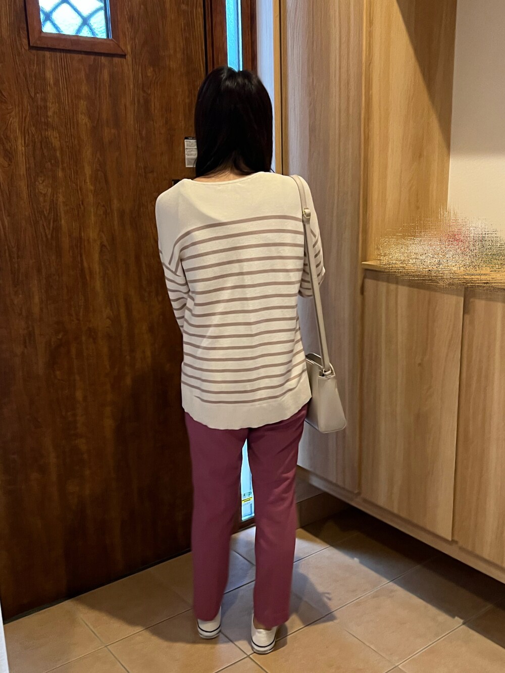 ピンク系のパンツ、ベージュ系のニット/セーター、ホワイト系のスニーカーを着用したレディースの秋コーディネートの4枚目の写真