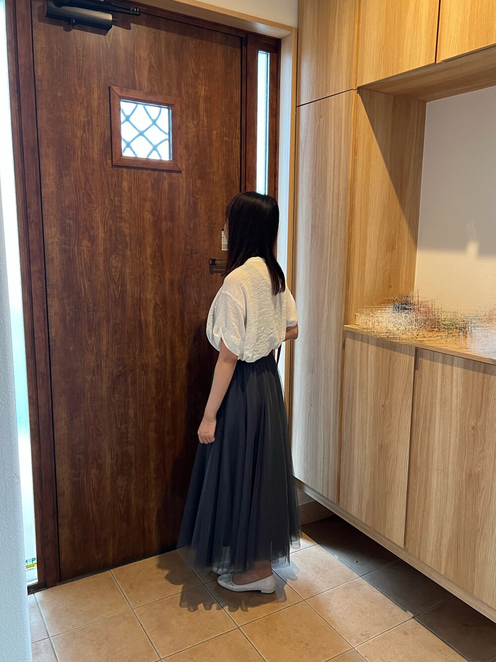 グレー系のスカート、ホワイト系のシャツ/ブラウス、ブラウン系のショルダーバッグを着用したレディースの秋コーディネートの2枚目の写真