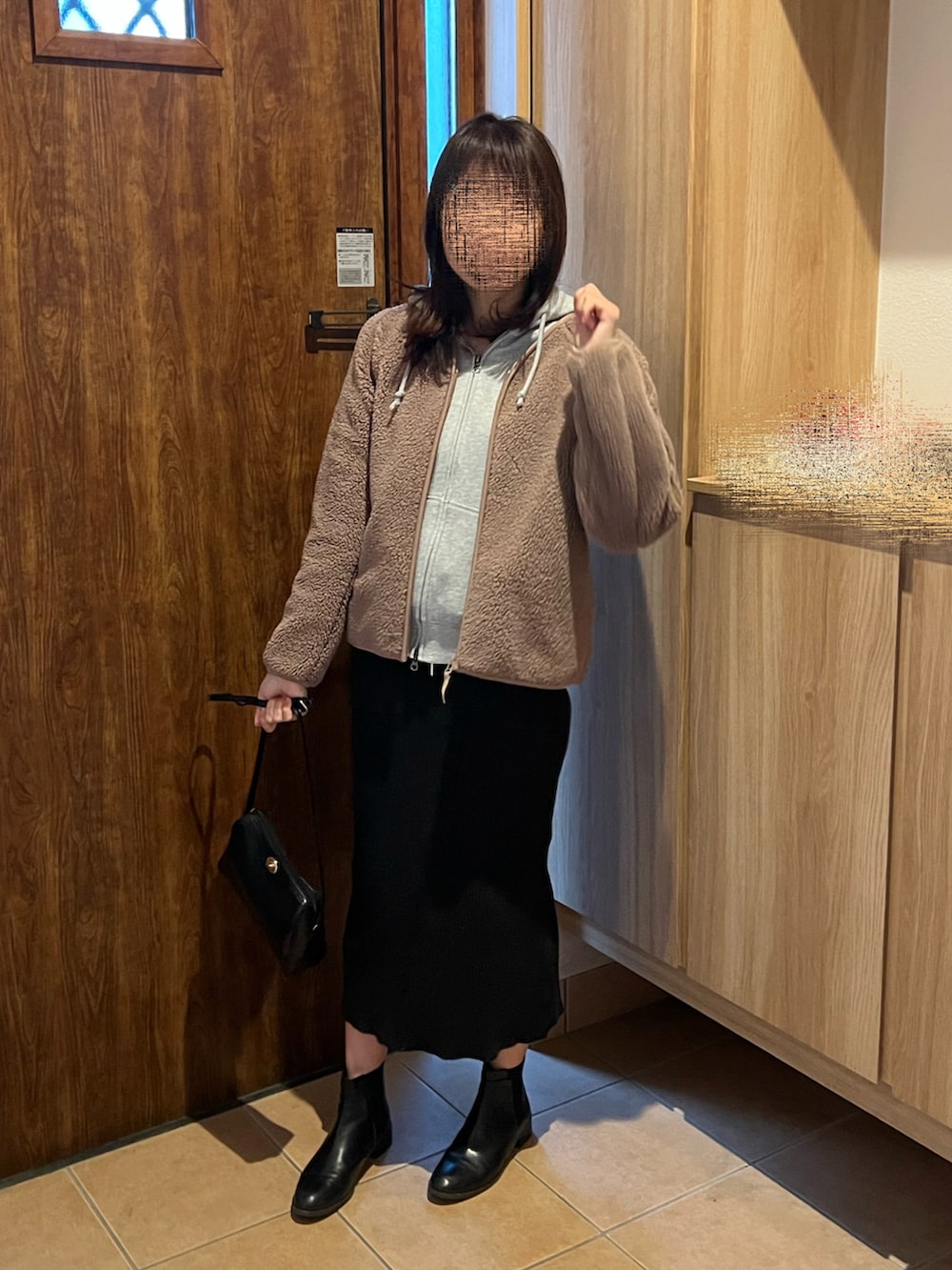 ブラック系のスカート、ブラック系のブーツ、ブラウン系のブルゾンを着用したレディースの冬コーディネートの3枚目の写真