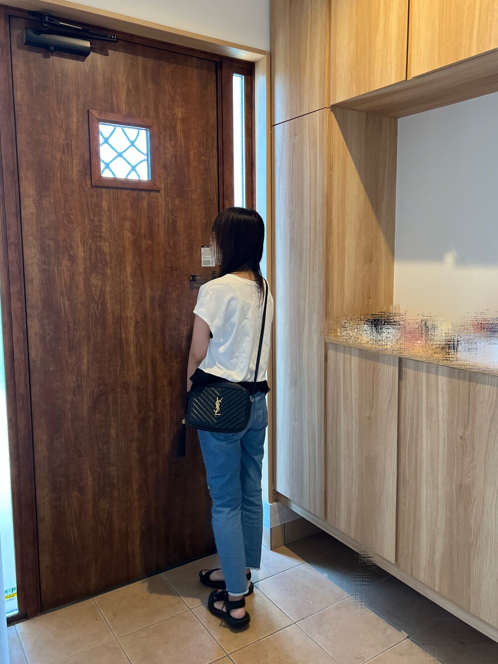 ホワイト系のTシャツ/カットソー、ブルー系のデニムパンツ、ブラック系のサンダルを着用したレディースの夏コーディネートの2枚目の写真