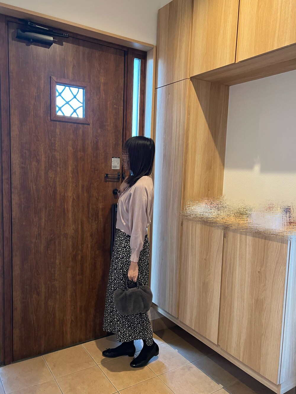 ピンク系のカーディガン/ボレロ、ブラック系のスカート、ブラック系のパンプスを着用したレディースの秋コーディネートの2枚目の写真