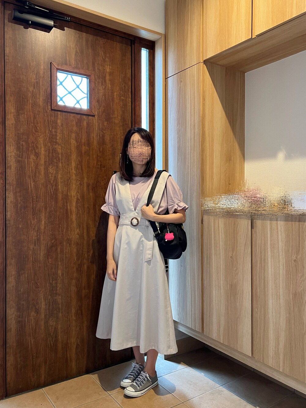 グレー系のジャンパースカート、パープル系のTシャツ/カットソー、ブラック系のバックパック/リュックを着用したレディースの夏コーディネートの3枚目の写真