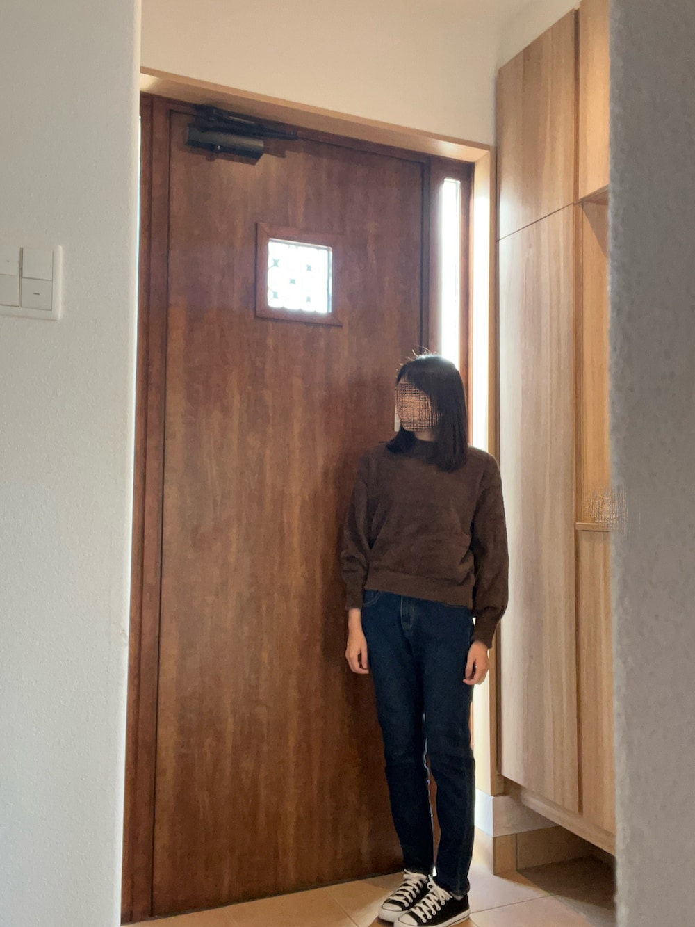 グレー系のダウンジャケット/コート、ブルー系のデニムパンツ、ブラック系のスニーカーを着用したレディースの冬コーディネートの2枚目の写真