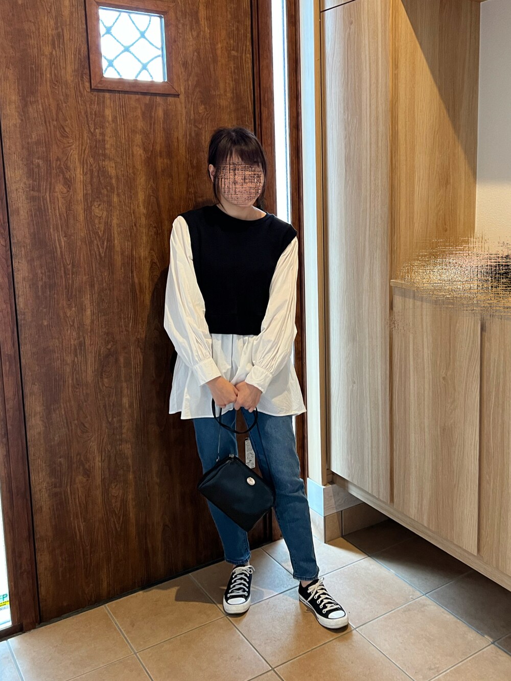 ブラック系のシャツ/ブラウス、ブラック系のショルダーバッグ、ブルー系のデニムパンツを着用したレディースの春コーディネートの4枚目の写真