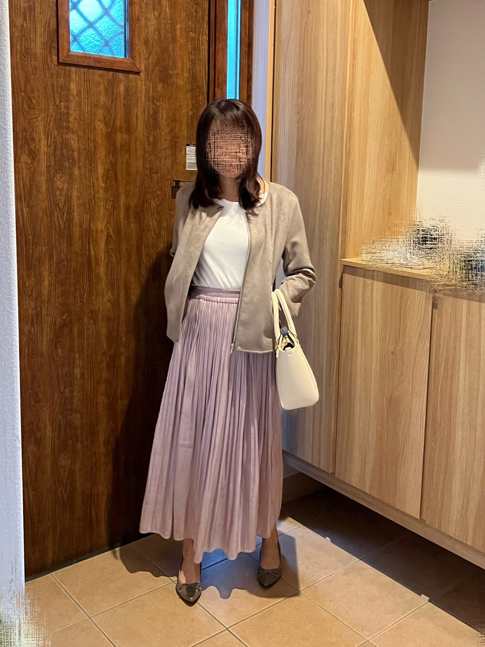 ホワイト系のハンドバッグ、ベージュ系のパンプス、ピンク系のスカートを着用したレディースの秋コーディネートの2枚目の写真