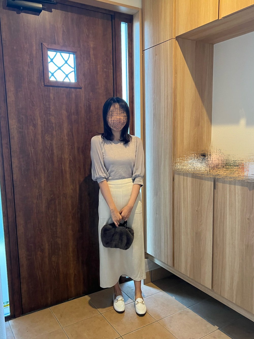 ホワイト系のスカート、ホワイト系のスリッポン、グレー系のTシャツ/カットソーを着用したレディースの秋コーディネートの3枚目の写真