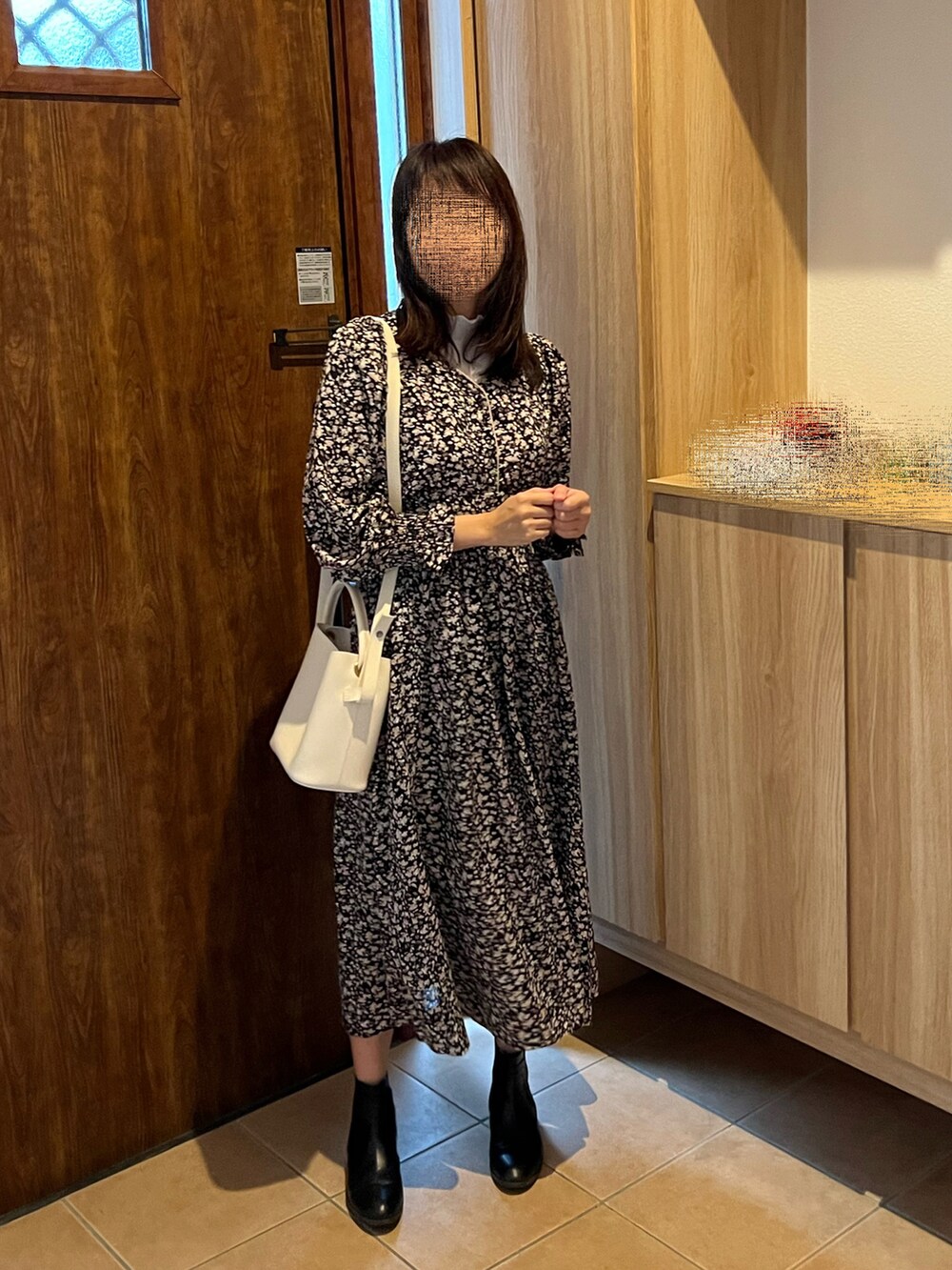 ブラック系のワンピース、ブラック系のダウンジャケット/コート、ブラック系のブーツを着用したレディースの秋コーディネートの2枚目の写真