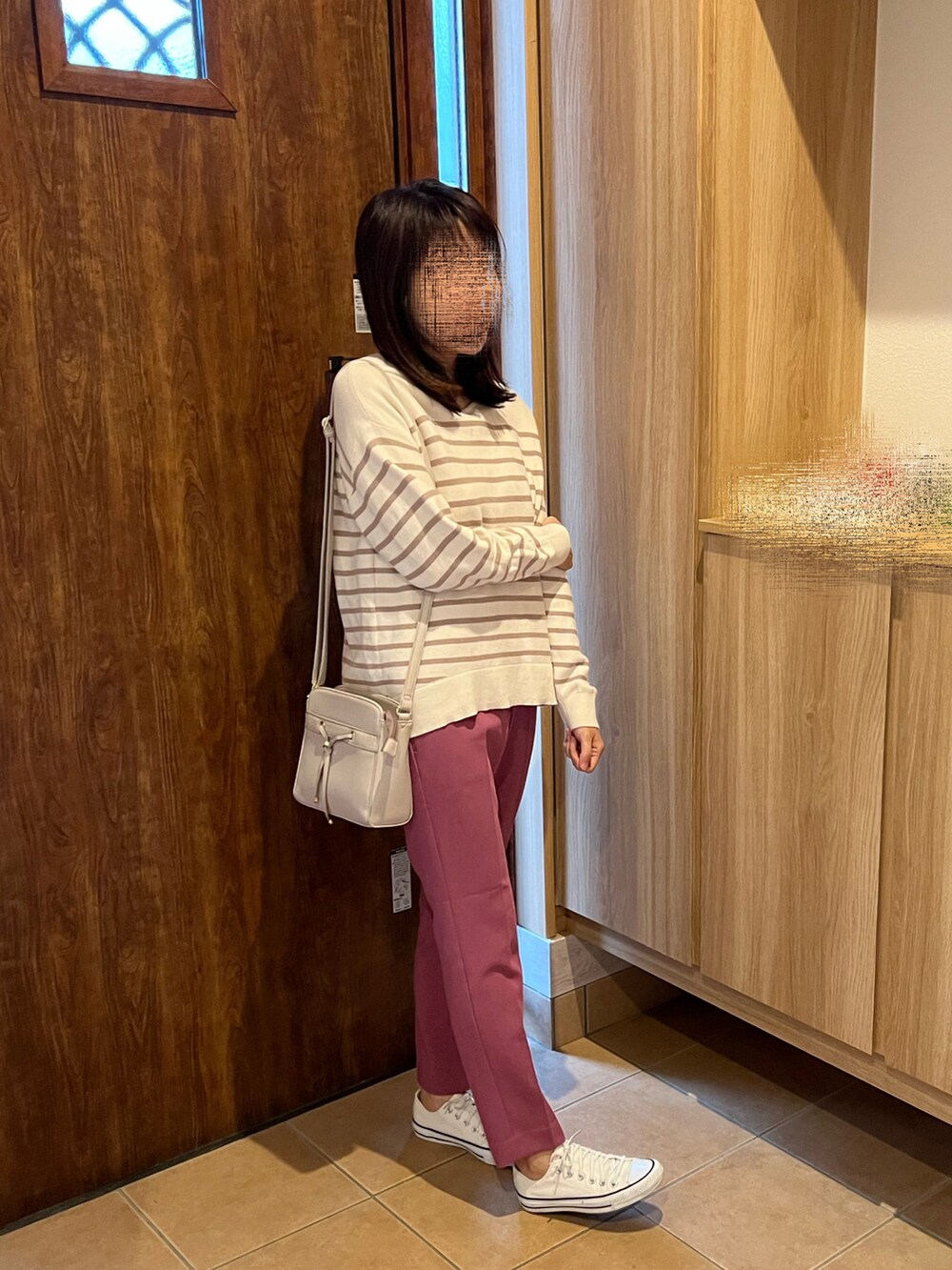 ピンク系のパンツ、ベージュ系のニット/セーター、ホワイト系のスニーカーを着用したレディースの秋コーディネートの3枚目の写真