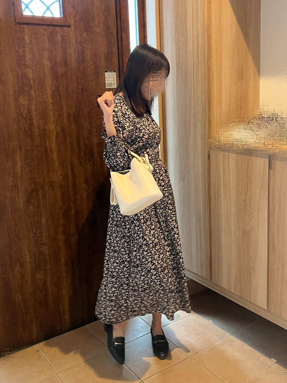 ブラック系のワンピース、ブラック系のローファー、ホワイト系のショルダーバッグを着用したレディースの秋コーディネートの3枚目の写真