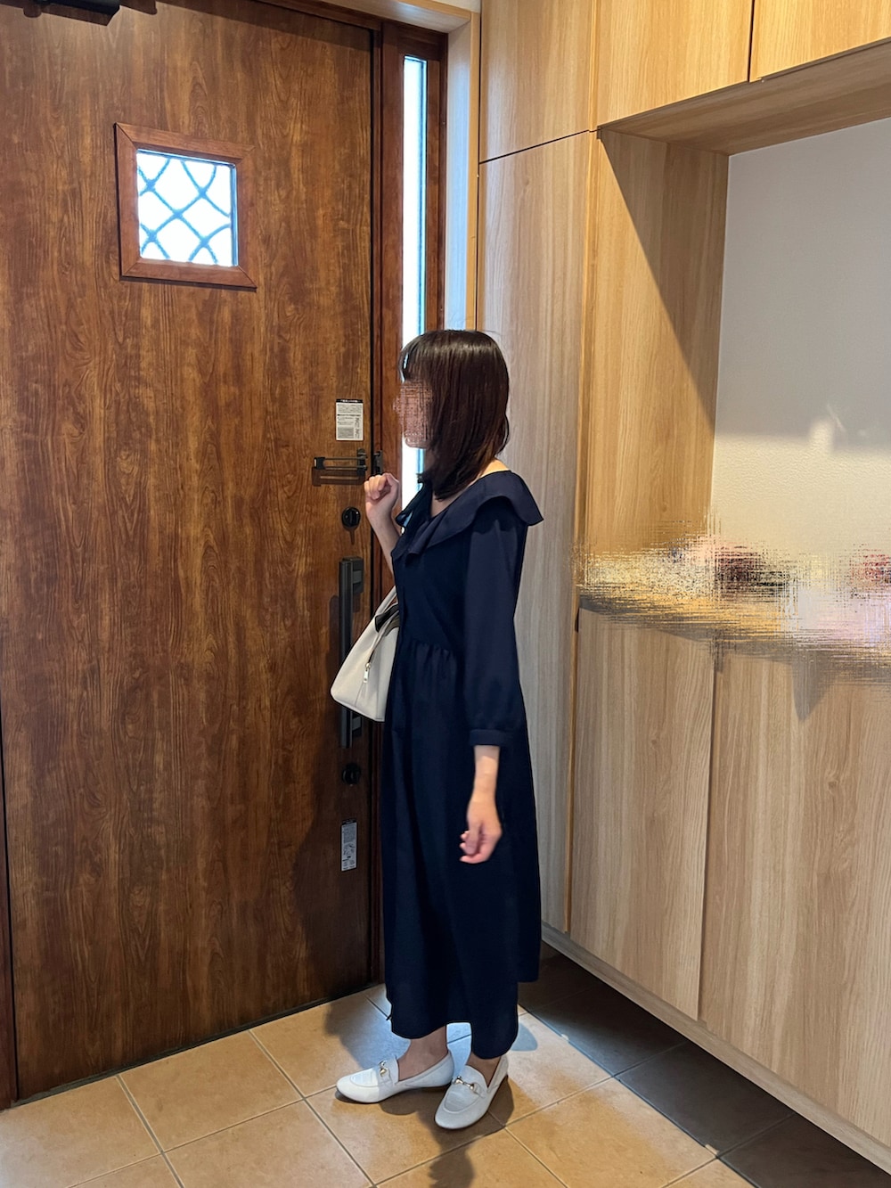 ブルー系のワンピース、ホワイト系のハンドバッグ、ホワイト系のスリッポンを着用したレディースの夏コーディネートの2枚目の写真