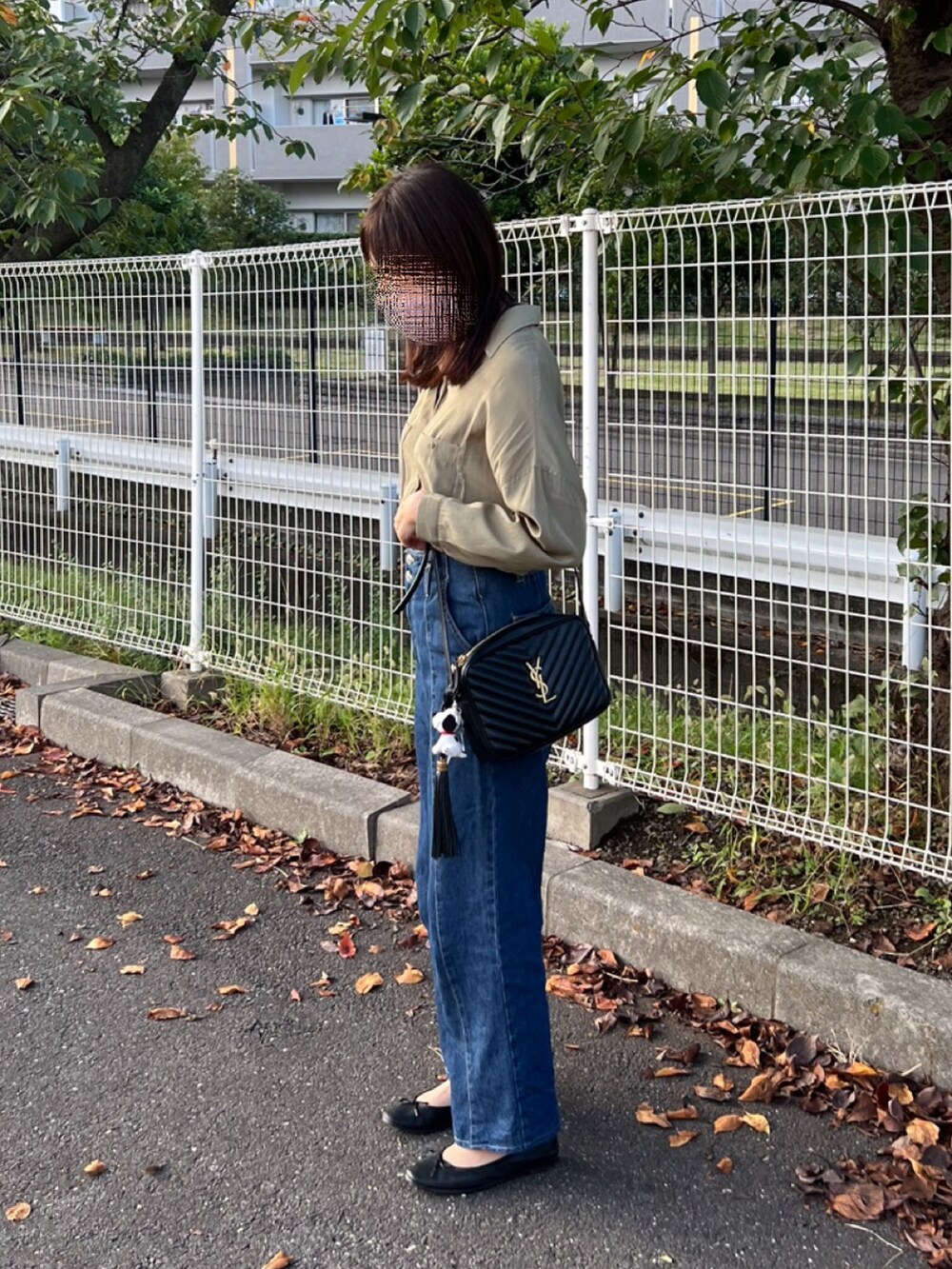 グリーン系のシャツ/ブラウス、ブラック系のショルダーバッグ、ブルー系のデニムパンツを着用したレディースの秋コーディネートの2枚目の写真