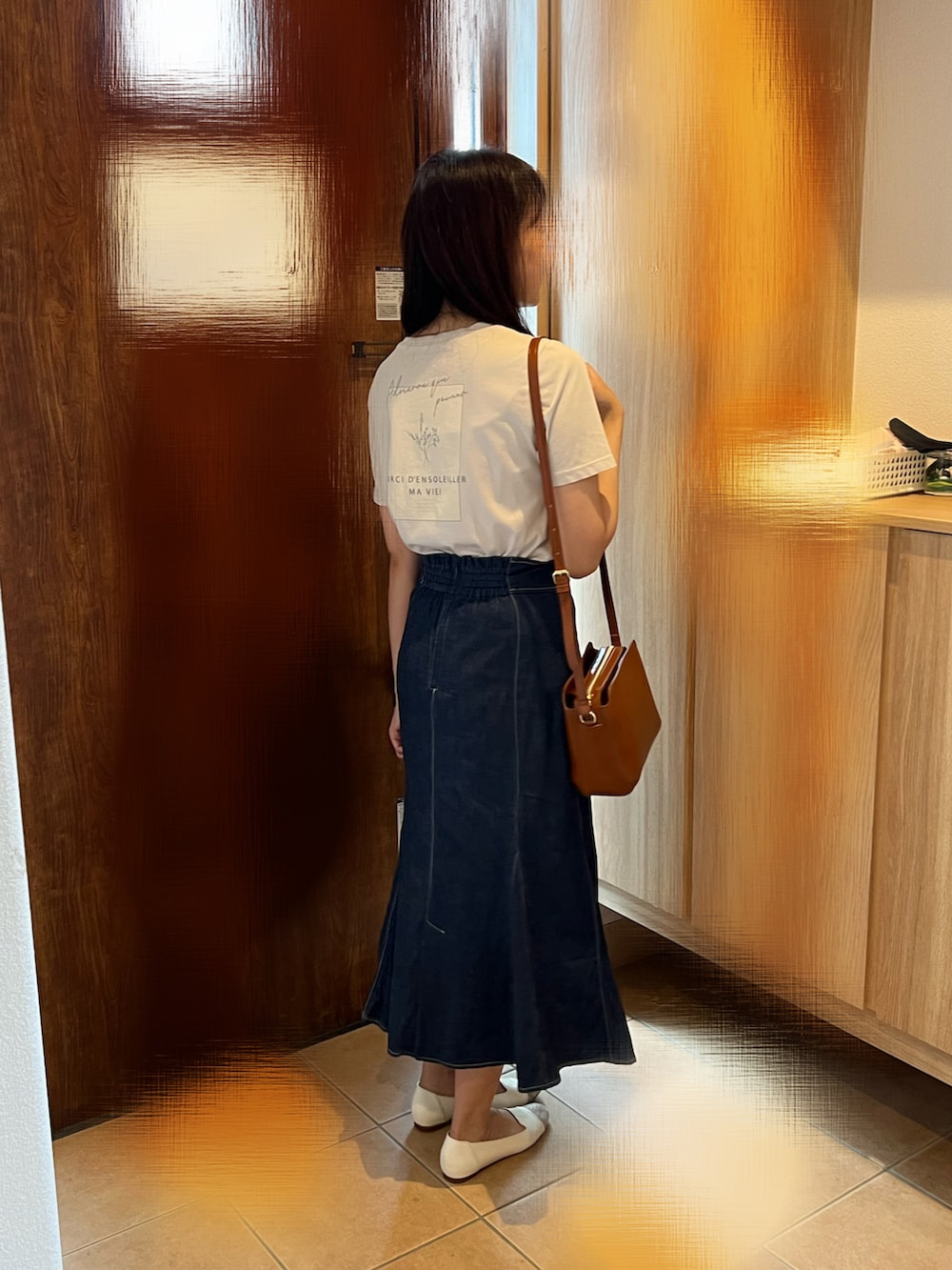 ブルー系のスカート、ベージュ系のTシャツ/カットソー、ホワイト系のパンプスを着用したレディースの夏コーディネートの2枚目の写真