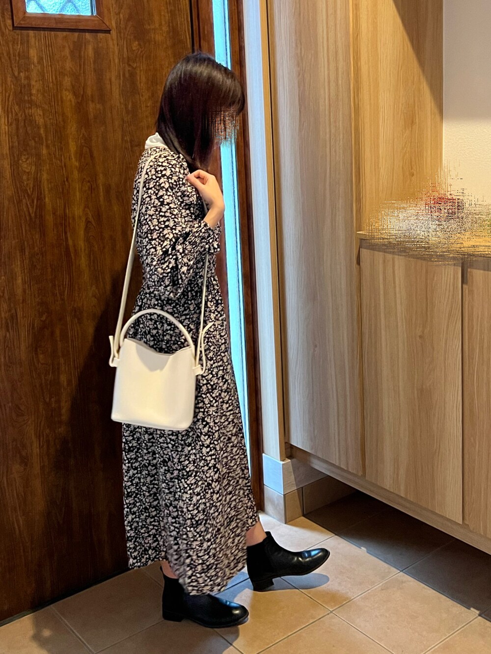 ブラック系のワンピース、ブラック系のダウンジャケット/コート、ブラック系のブーツを着用したレディースの秋コーディネートの3枚目の写真