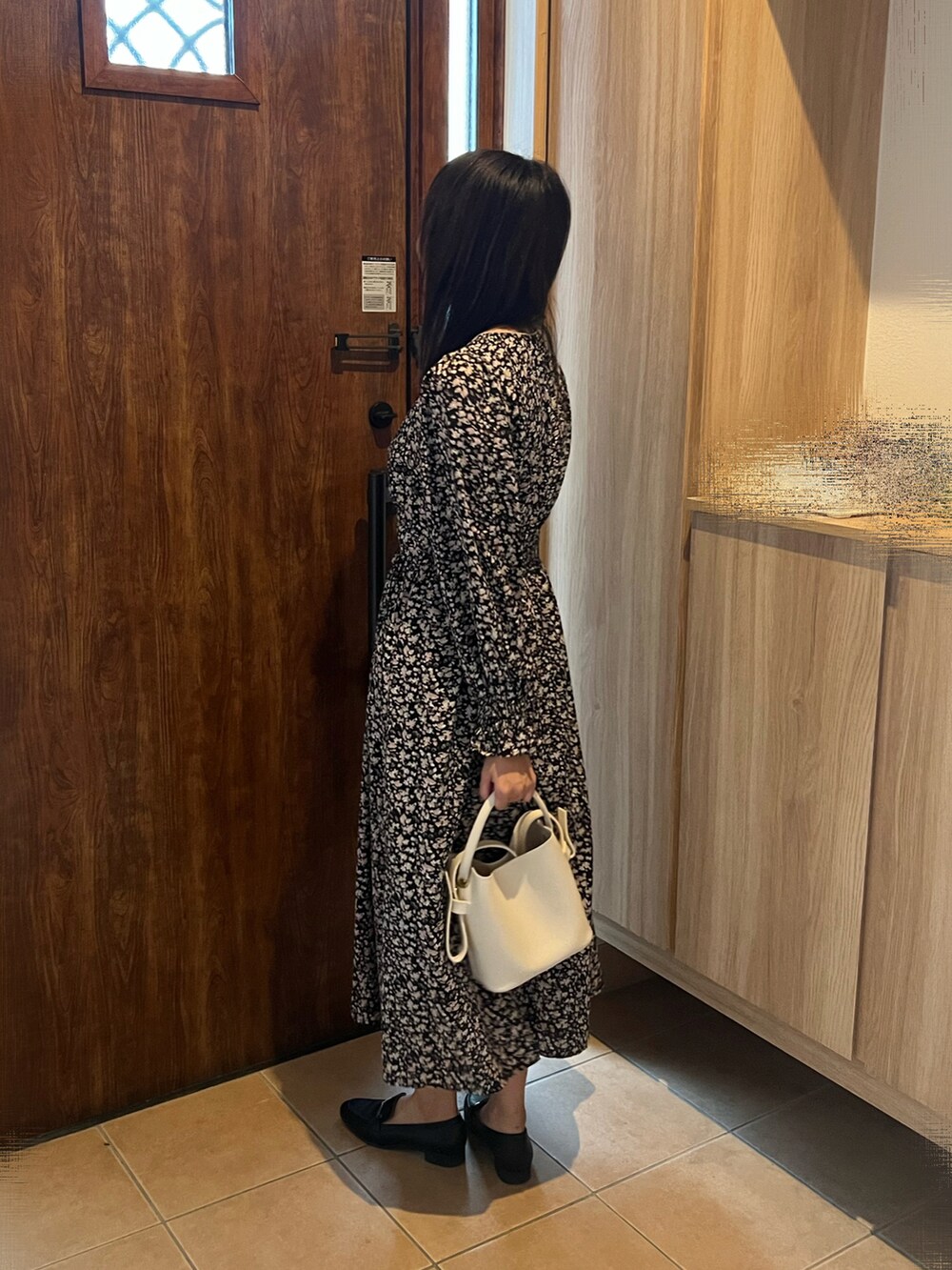 ブラック系のワンピース、ブラック系のローファー、ホワイト系のショルダーバッグを着用したレディースの秋コーディネートの4枚目の写真