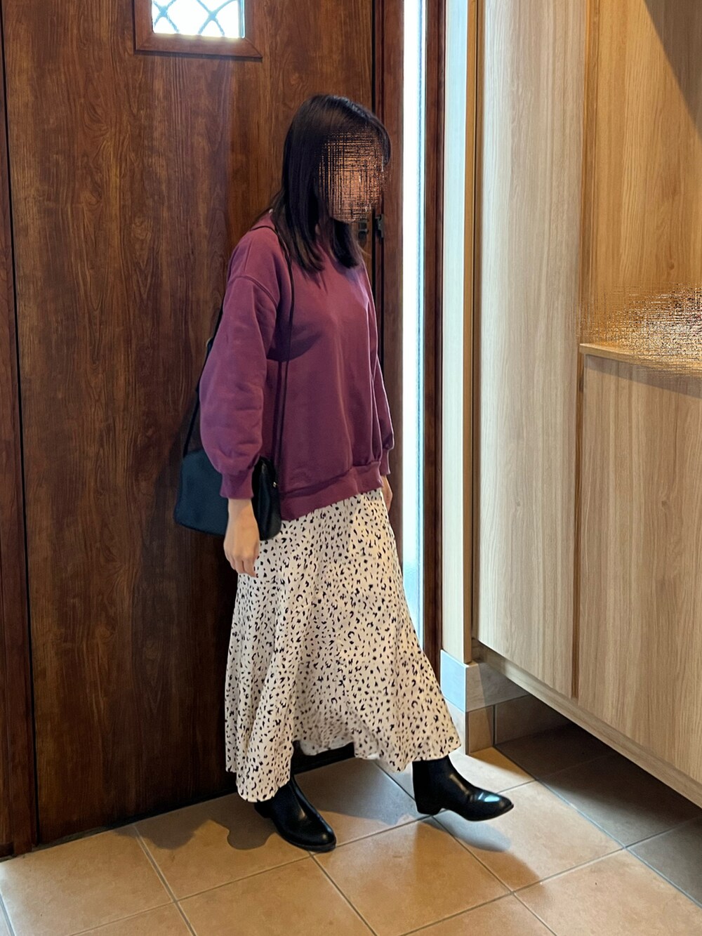 パープル系のスウェット、ホワイト系のスカート、ブラック系のブーツを着用したレディースの冬コーディネートの2枚目の写真