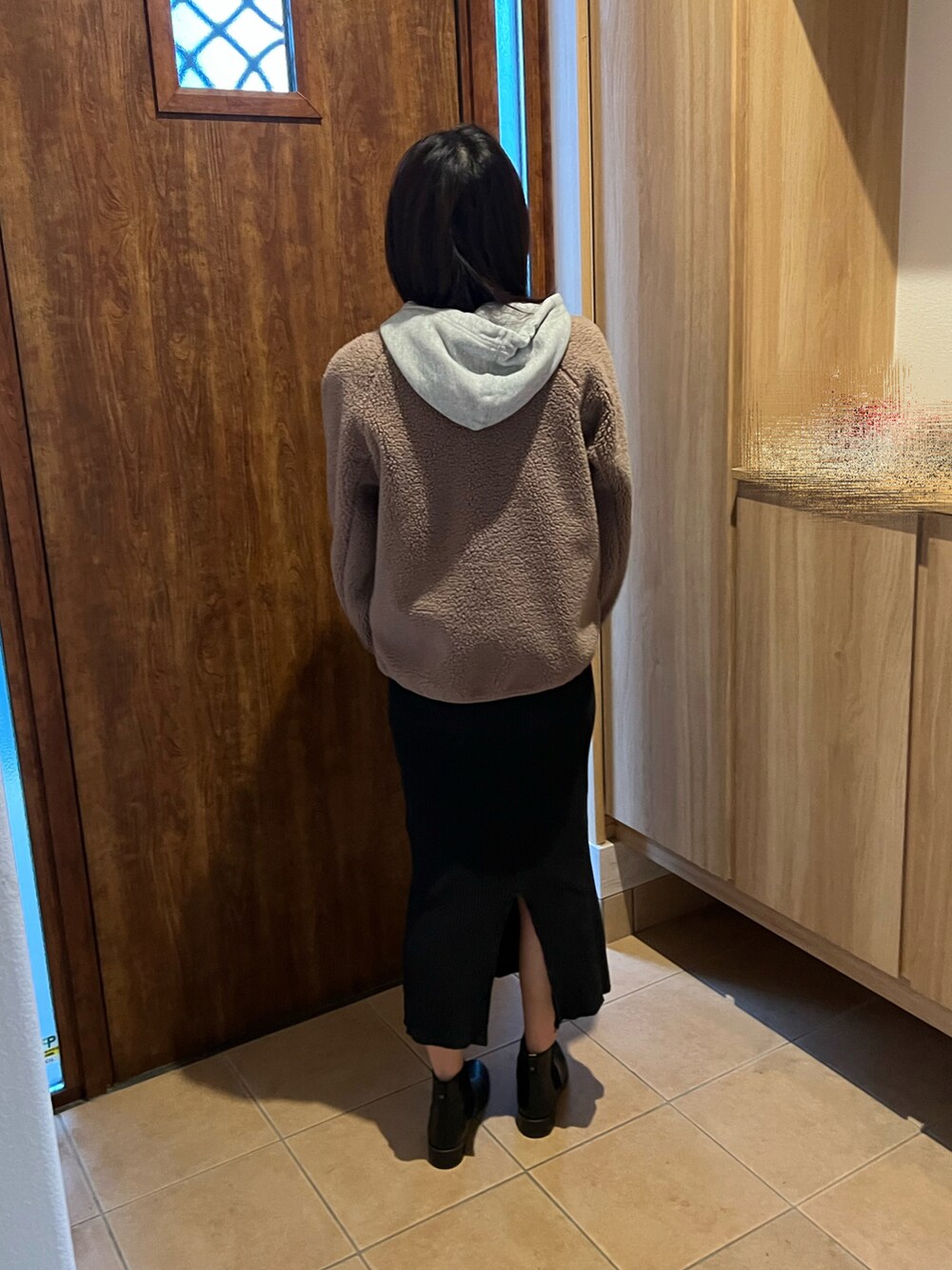 ブラック系のスカート、ブラック系のブーツ、ブラウン系のブルゾンを着用したレディースの冬コーディネートの4枚目の写真