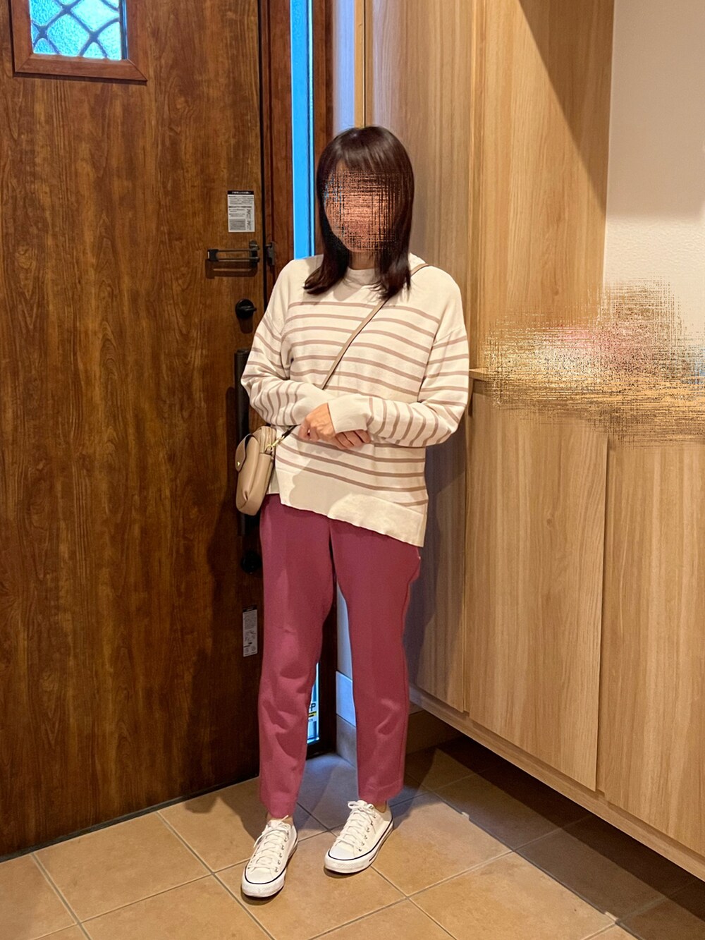 ベージュ系のニット/セーター、ピンク系のパンツ、ホワイト系のスニーカーを着用したレディースの冬コーディネートの3枚目の写真